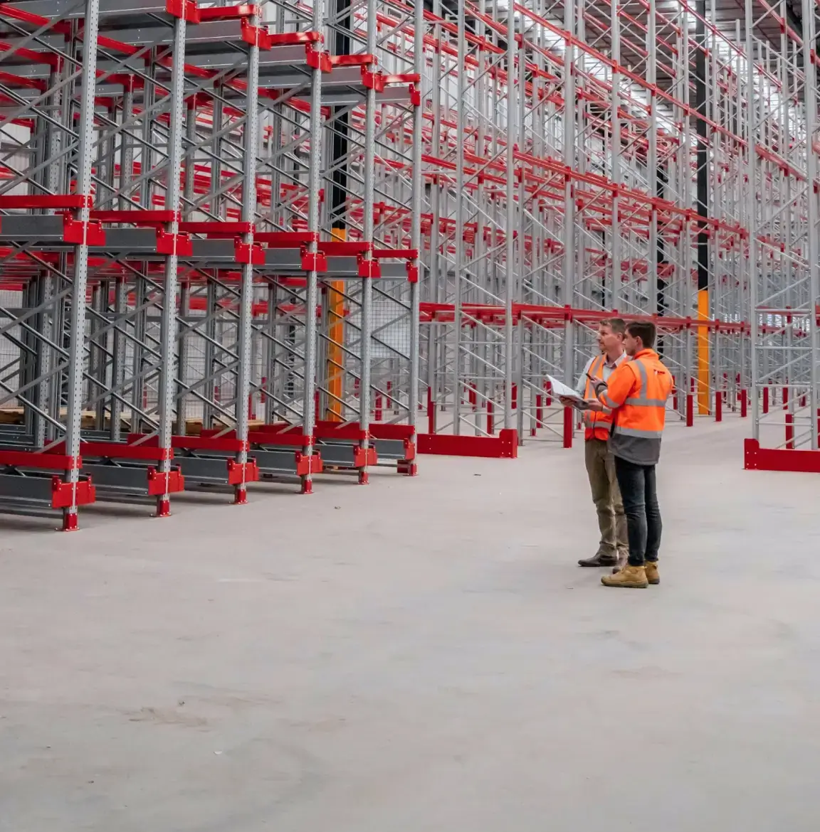 Warehouse staff reviewing large-scale pallet racking system